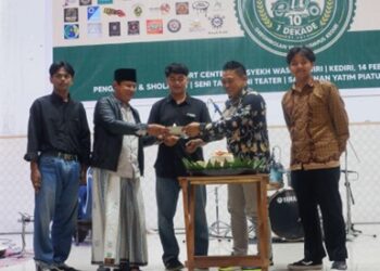 Prosesi potong tumpeng dalam peringatan satu dekade Gerombolan Vespa Kediri di Gedung Sport Center UIN Syekh Wasil Kediri.
