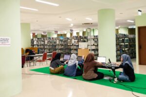Mahasiswa belajar di ruang baca perpustakaan. 